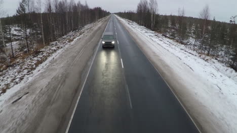 Aerial-shot-of-minivan-on-winter-road