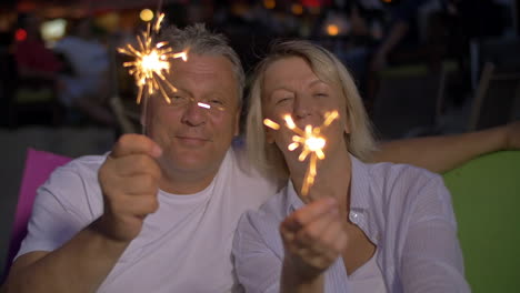 Pareja-Mayor-Con-Luces-De-Bengala-Al-Aire-Libre-Por-La-Noche