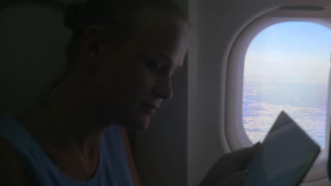 Frau-Mit-Tablet-Am-Flugzeugfenster
