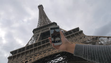 Woman-with-cellphone-taking-photo-of-Eiffel-Tower