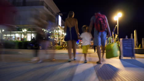 Hyperlapse-of-family-walking-along-street-at-night