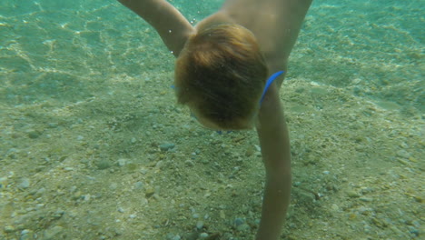 Kleiner-Junge-Schwimmt-Unter-Wasser,-Um-Eine-Muschel-Zu-Nehmen