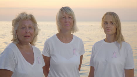 Tres-Mujeres-Con-Cintas-Rosas-De-Concientización-Sobre-El-Cáncer-De-Mama