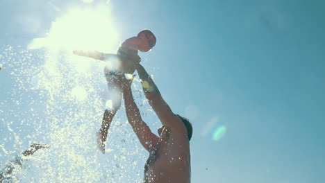 Father-throwing-son-up-from-the-water