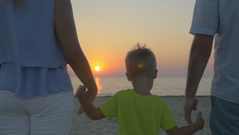 Familie-Mit-Kind-Blickt-Auf-Den-Sonnenuntergang-über-Dem-Meer