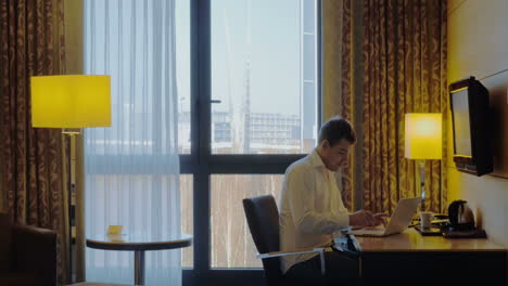 Young-businessman-busy-with-work-in-hotel-room