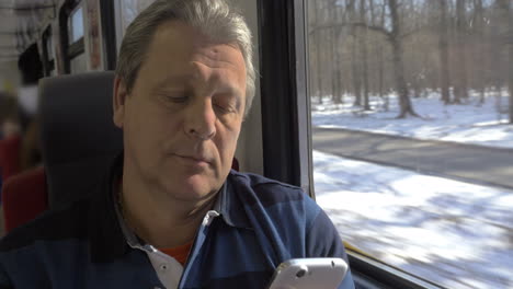 Mature-Man-Using-Smartphone-while-Train-Trip