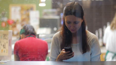 Junges-Brünettes-Mädchen-Benutzt-Smartphone-Im-Café