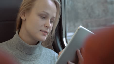 Smiling-Woman-with-Tablet-in-Train