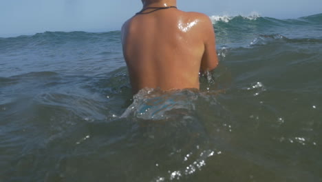 Niño-Con-Pelota-Nadando-En-El-Mar-Ondulado