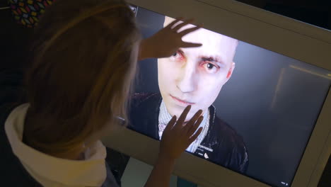 Woman-looking-at-3D-human-model-on-touchscreen-monitor