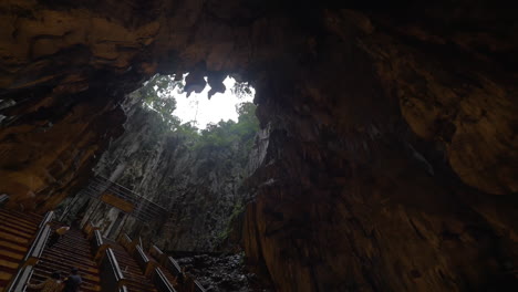 In-Batu-Höhlen-Gesehene-Höhle-Mit-Stalaktiten-Und-Wandertouristen,-Die-Die-Treppe-Hinaufsteigen