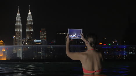 Frau-Mit-Polster-Schießt-Nacht-In-Kuala-Lumpur-Vom-Pool-Auf-Dem-Dach-Aus