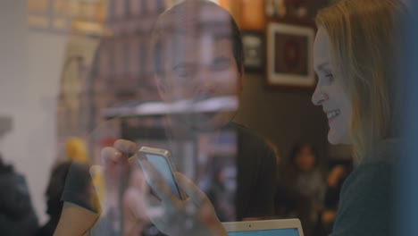 Frau-Und-Mann-Unterhalten-Sich-Im-Restaurant-Per-Smartphone