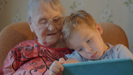 Boy-Showing-Something-in-Tablet-to-his-Grandmother