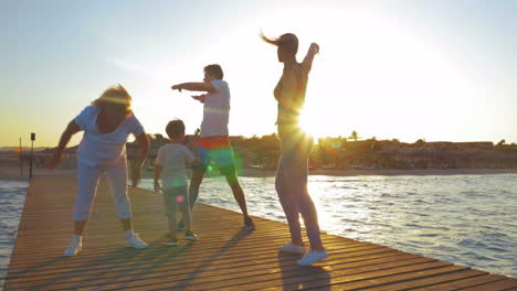 Family-exercising-on-the-pier-at-sunset