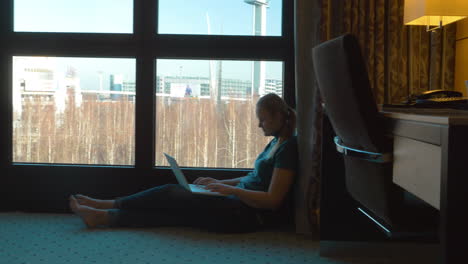 Frau-Benutzt-Laptop-Am-Fenster-Im-Hotelzimmer