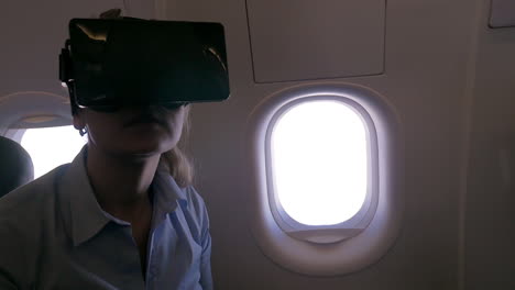 Zeitlupenansicht-Einer-Frau,-Die-Im-Flugzeug-Einen-VR-Helm-Für-Ihr-Smartphone-Benutzt