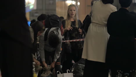 Female-Aid-Worker-Distributing-Clothes-at-Charity-Collecting-Point-in-Copenhagen-Railroad-Station