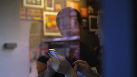 Frau-Und-Mann-Unterhalten-Sich-Im-Restaurant-Per-Smartphone