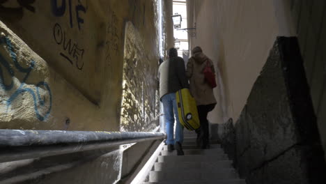 Two-tourists-walking-in-old-narrow-street-Stockholm