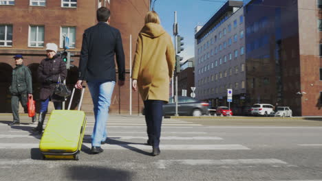 Hombre-Y-Mujer-Con-Maleta-Cruzando-La-Calle