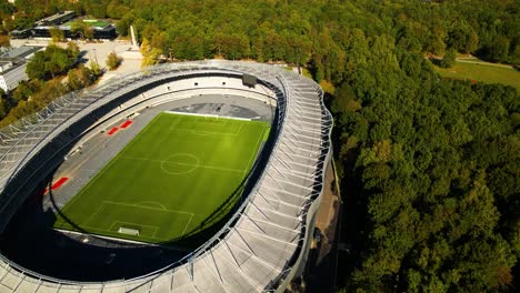 aerial-shot-of-a-newly-opened-Darius-and-Girenas-Stadium-and-oak-tree-park-on-a-sunny-summer-day-in-Kaunas,-Lithuania,-zooming-out