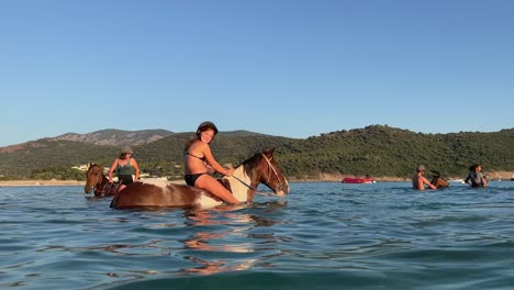 Libertad-Y-Tranquilidad-Para-Los-Jinetes-Mientras-Se-Sumergen-En-La-Belleza-Del-Mar,-Disfrutando-De-Un-Paseo-A-Caballo-A-Pelo.