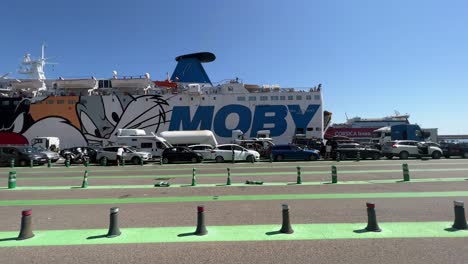 Ferry-boat-waits-for-passengers-and-cars-at-port-queuing-for-boarding