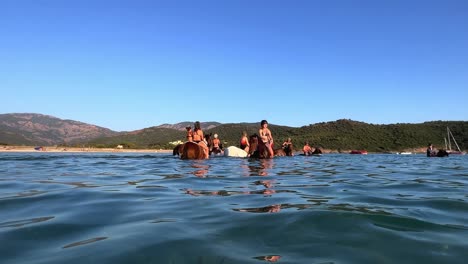 La-Gente-Disfruta-De-Una-Experiencia-única-De-Montar-A-Caballo-En-Las-Refrescantes-Aguas-Del-Mar.