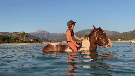 Adolescente-Pelirroja-En-Bikini-Disfrutando-De-Un-Refrescante-Paseo-A-Caballo-En-La-Temporada-De-Verano