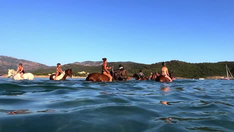 Eine-Gruppe-Von-Menschen-Hat-In-Der-Sommersaison-Spaß-Beim-Reiten-Im-Meerwasser