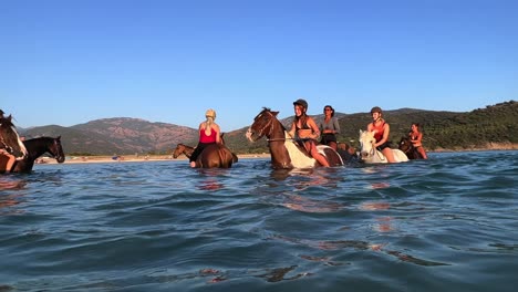 Horse-riders-on-bareback-adventure-amidst-gentle-waves-of-ocean