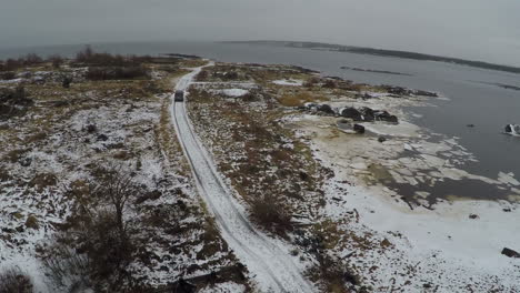 Flying-over-minivan-driving-on-winter-shore