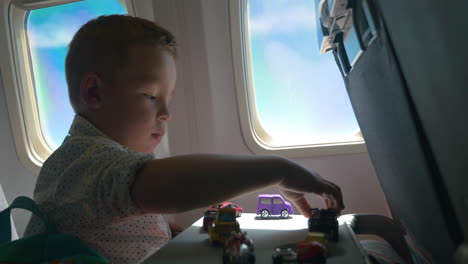 Little-kid-playing-with-toy-cars-in-the-airplane
