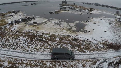 Überfliegen-Eines-Autos,-Das-Im-Winter-Am-Wasser-Entlangfährt