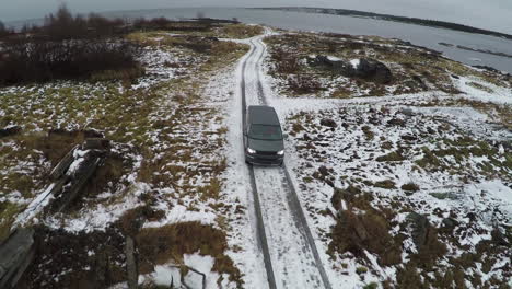 Luftaufnahme-Eines-Autos,-Das-Im-Winter-Vom-Ufer-Wegfährt