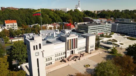 Aerial-shot-of-the-Unity-Square-and-war-museum-with-Lithuanian-flag-in-Kaunas,-in-Lithuania-on-a-sunny-summer-day