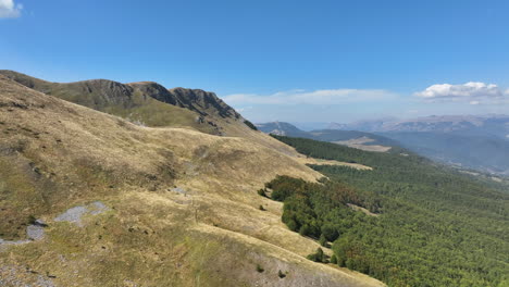 Vuelo-Sobre-Hermosos-Picos-Montañosos-Cubiertos-De-Hierba