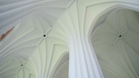 Low-angle-of-white-ceiling-and-pillar-of-the-church-of-Saint-Mary's-Scapular-in-Druskininkai,-Lithuania