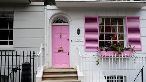 Charming-white-facade-with-pink-door-at-Fourteen-Trevor-Square,-Knightsbridge,-London