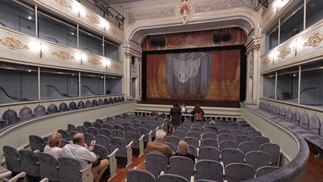 Timelapse-of-people-entering-and-sitting-in-old-theatre-Carlos-III-in-San-Lorenzo-de-El-Escorial,-Madrid,-Spain