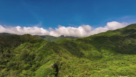 Aerial-approaching-shot-of-green-island-with-overgrown-mountain-and-blue-sky---Orchid-Island-in-Taiwan