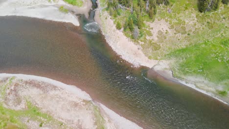 Soaring-above-the-pristine-wilderness,-the-daytime-aerial-view-of-the-Yellowstone-River-unveils-a-landscape-of-unparalleled-natural-beauty