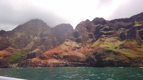Gimbal-Wide-POV-Aufnahme-Von-Einem-Fahrenden-Boot-Aus-Auf-Die-Einzigartigen-Und-Farbenfrohen-Bergrücken-Entlang-Der-Küste-Von-Na-Pali-Auf-Der-Insel-Kaua&#39;i,-Hawaii