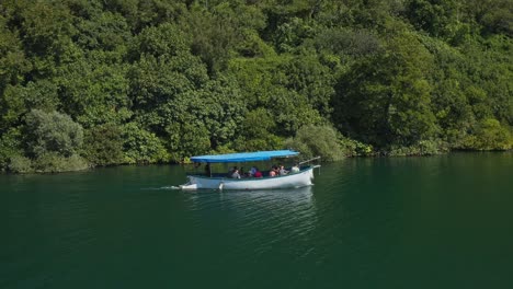 Parque-Nacional-De-Krka,-Dalmacia-Central,-Croacia---Turistas-Pilotando-Un-Barco-A-Lo-Largo-Del-Río-Krka---Toma-De-Seguimiento