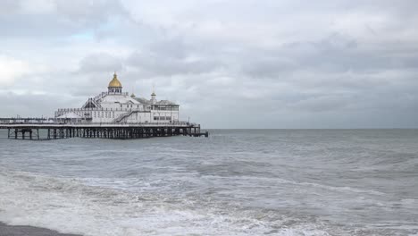 Große-Wellen,-Die-Von-Starken-Winden-Aufgewirbelt-Werden,-Brechen-Am-Strand-Vor-Einem-Vergnügungspier,-Bevor-Der-Sturm-Ciarán-Auf-Land-Trifft