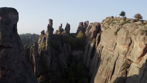 Zipline-aerial-drone-shot-moving-towards-the-massive-natural-rock-formations-of-the-Belogradchik-Cliffs,-located-in-the-province-of-Vidin-in-Northwestern-Bulgaria