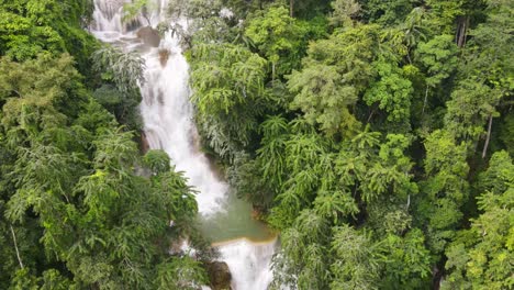 Aerial-View-Of-Kuang-Si-Falls-Cascading-Down-Surrounding-By-Tropical-Forest-Trees-In-Luang-Prabang