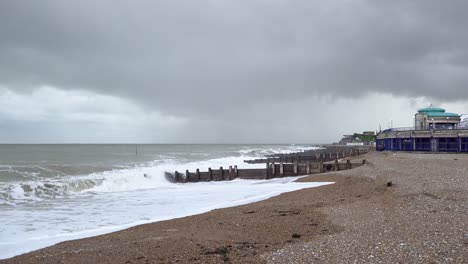 Large-and-threatening-waves-break-between-groynes-and-crash-on-to-the-beach-and-dark-clouds-roll-in-as-storm-Ciarán-makes-landfall